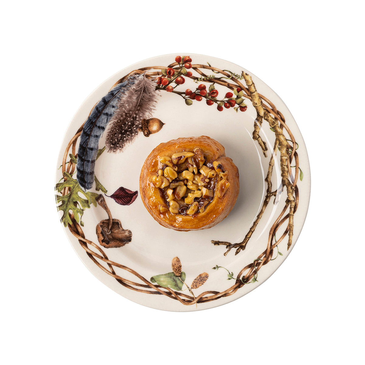 Juliska Forest Walk party plate holding a pastry, with a painted feather and berry wreath