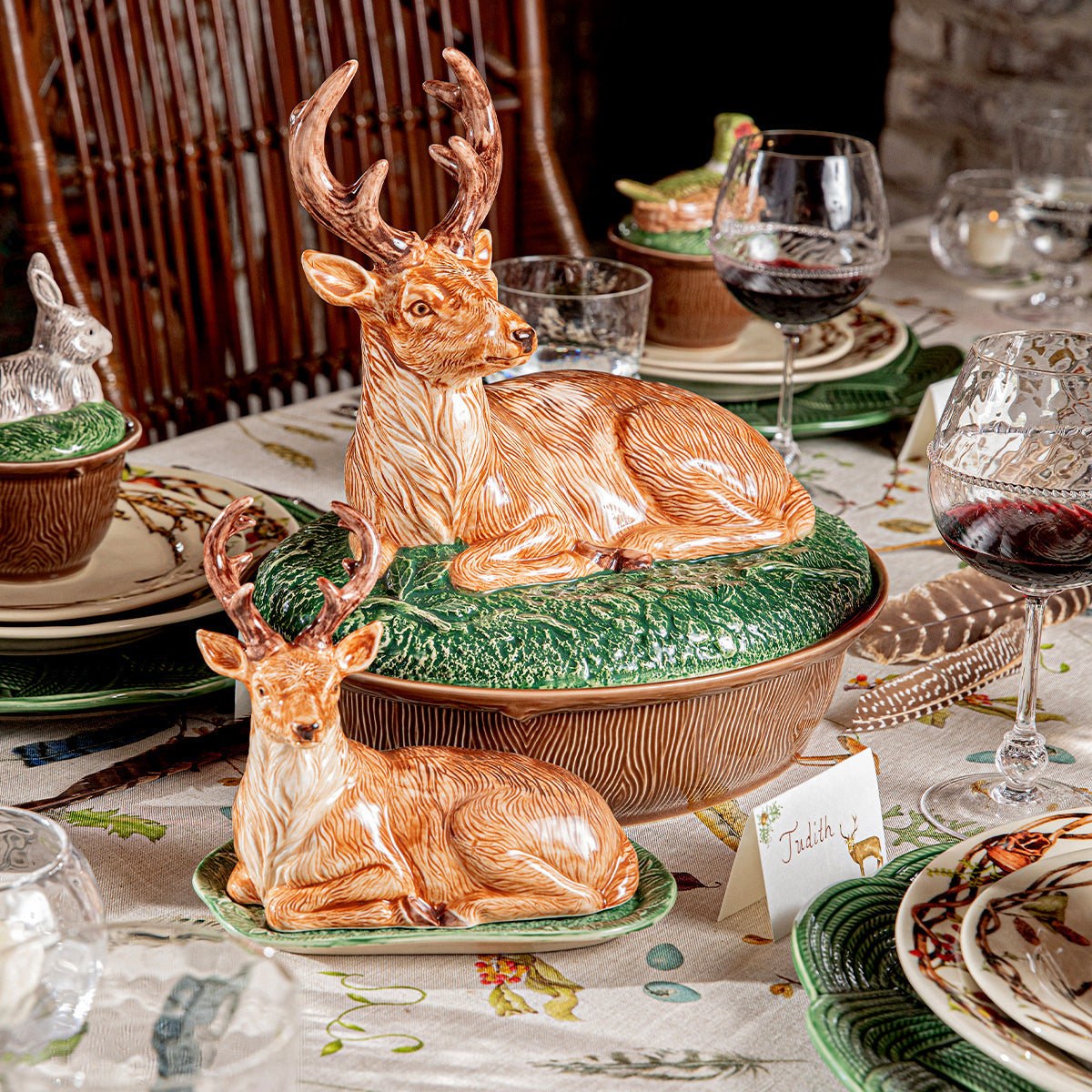 Forest Walk stag lidded baker beside a deer lidded bowl on a set dinner table