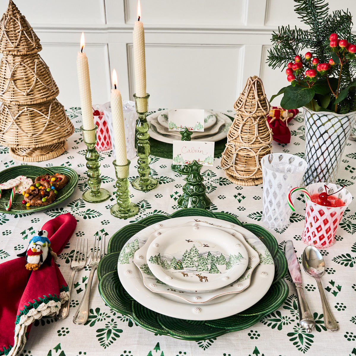 Holiday table set with North Pole place cards, green chargers and gold tree decorations