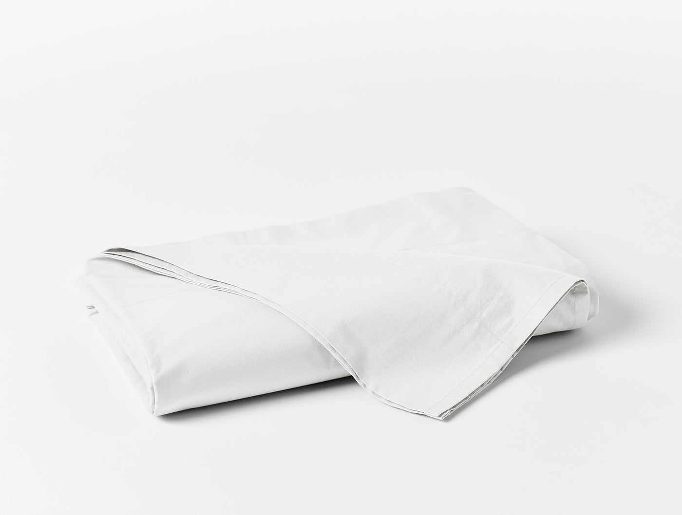 Coyuchi Refined Percale flat sheet in white, neatly folded on a light background.