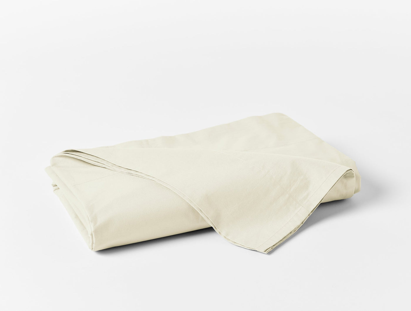 Folded ivory Coyuchi Refined Percale flat sheet showing smooth, crisp cotton fabric.