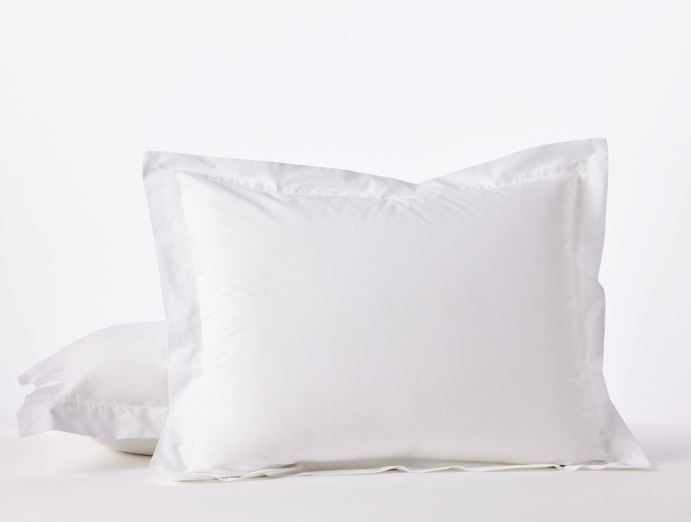 Coyuchi Refined Percale pillow sham in white, stacked pair with flanged border.