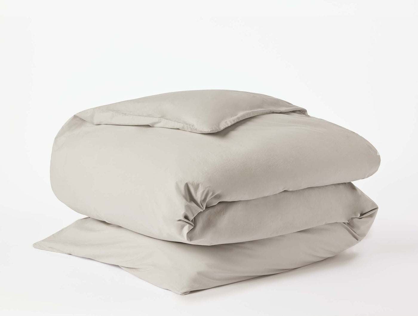 Coyuchi Refined Percale duvet cover folded neatly, shown in warm stone against white background.