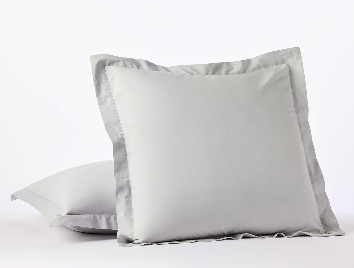 Two silver Coyuchi Refined Percale shams stacked, showing tailored flange border detail.