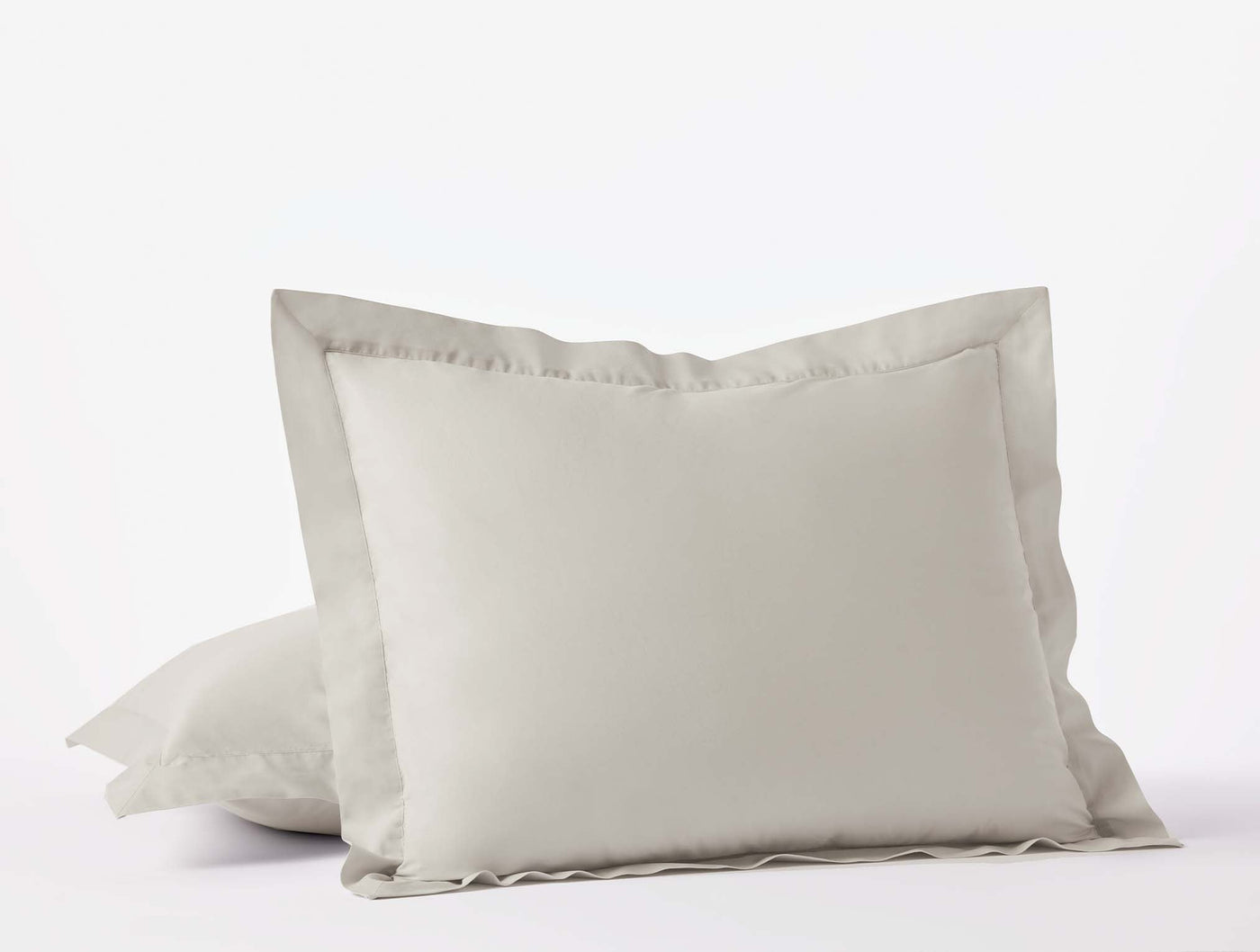 Close-up of Coyuchi Refined Percale shams in ivory with ruffled border detail.