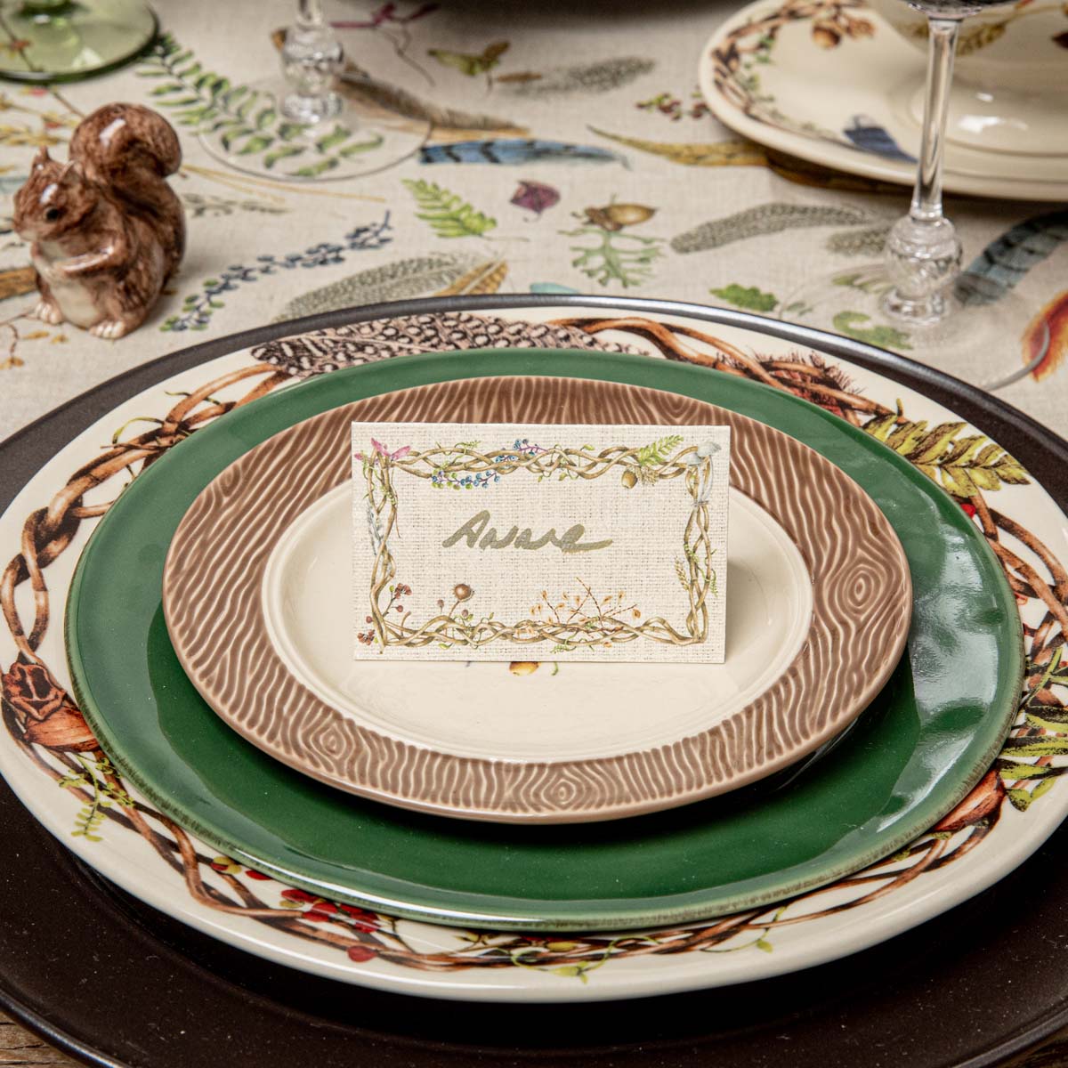 Twig border place card with a handwritten name on stacked Forest Walk plates