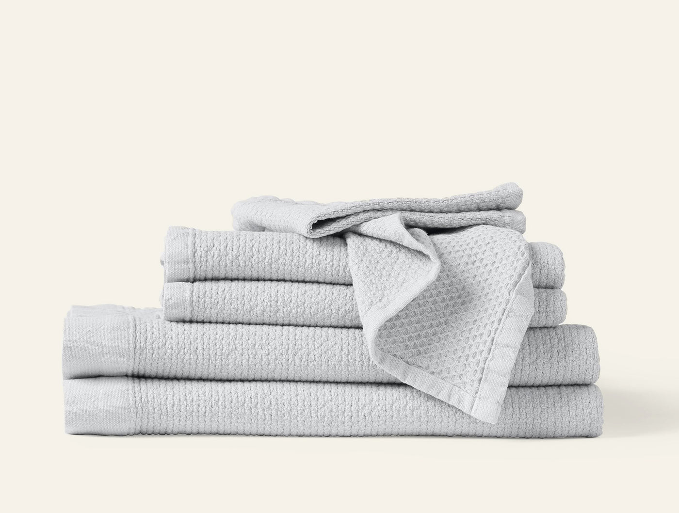 Coyuchi Adriatic towel set stacked in silver, showing waffle-textured weave detail.