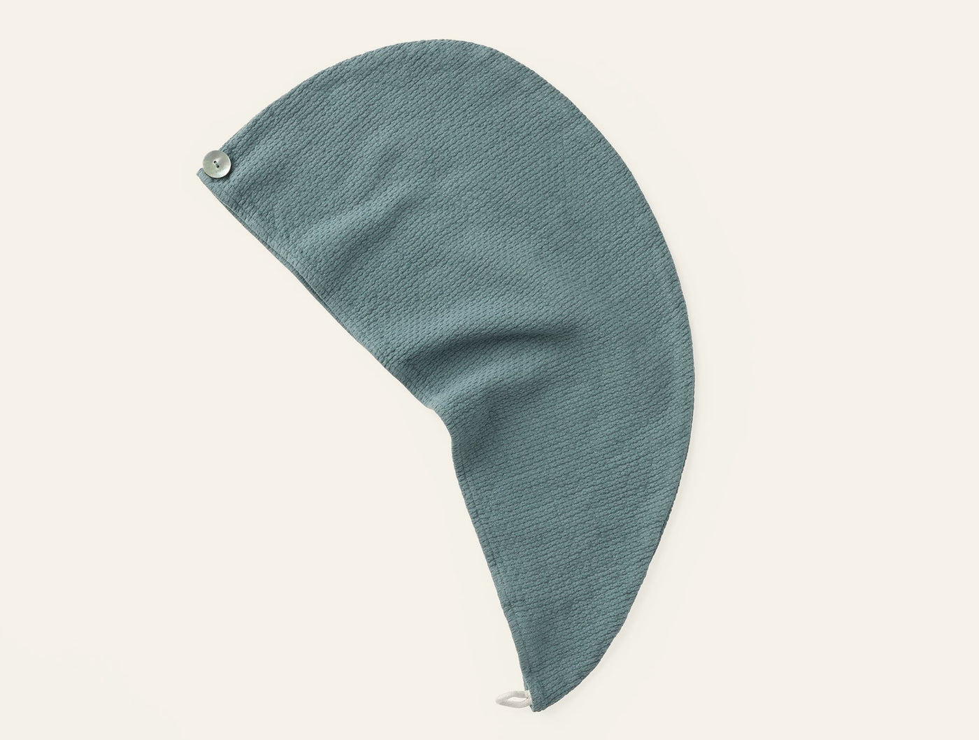 Close-up of Coyuchi Adriatic hair wrap in sage green with ribbed texture and button closure.