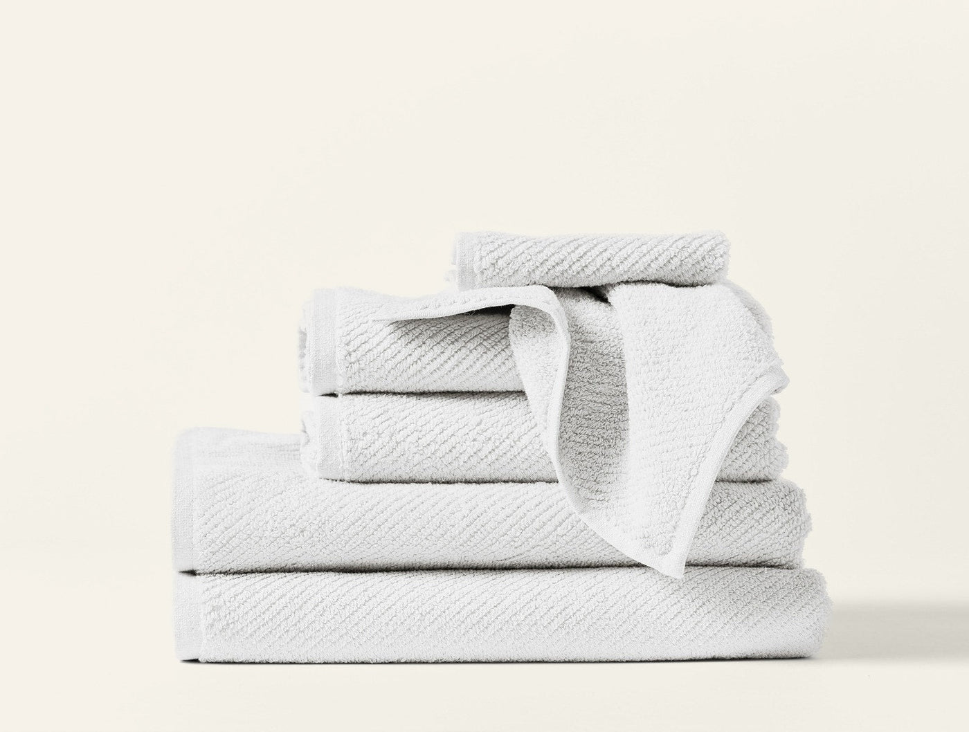 Coyuchi Air Weight 6-piece towel set in white, stacked with textured weave detail.