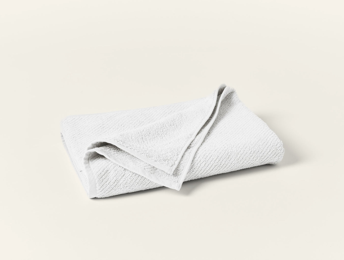 Coyuchi Air Weight guest towel in white, folded flat against a white background.