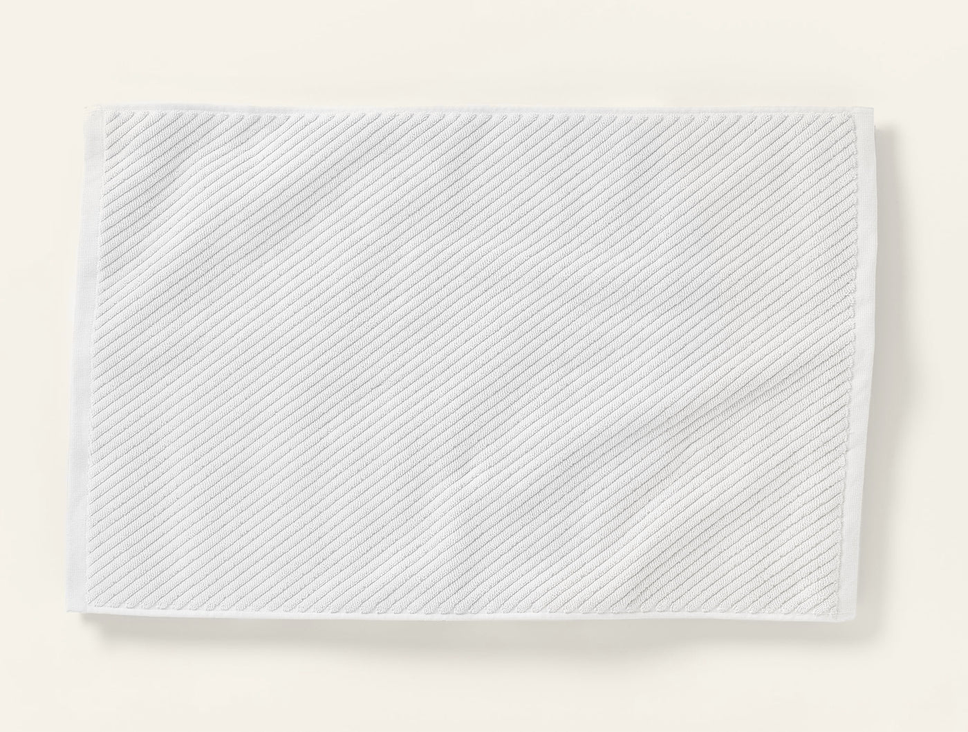 Coyuchi Air Weight white twill bath rug with diagonal ribbed texture.