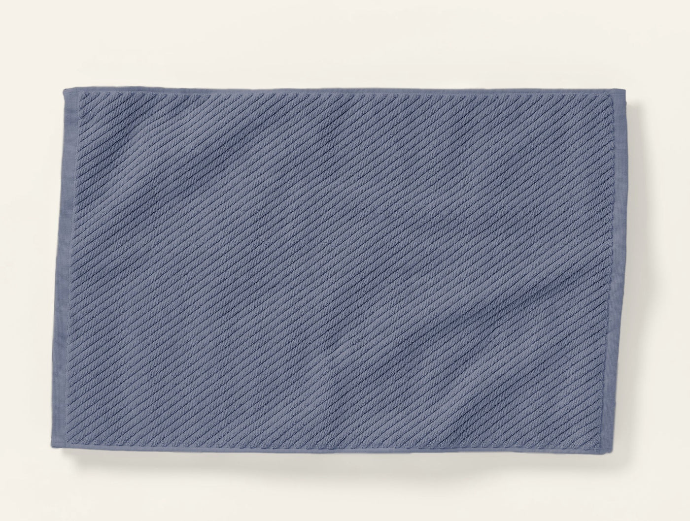Coyuchi Air Weight bath rug in slate blue, diagonal ribbed twill texture, flat lay.