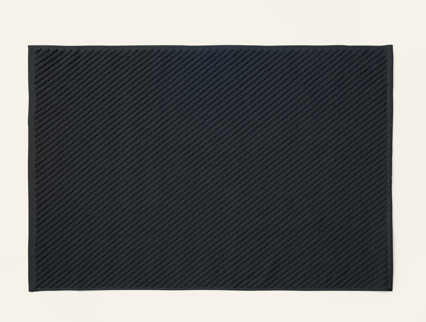 Coyuchi Air Weight bath rug in navy, showing diagonal twill weave texture detail.