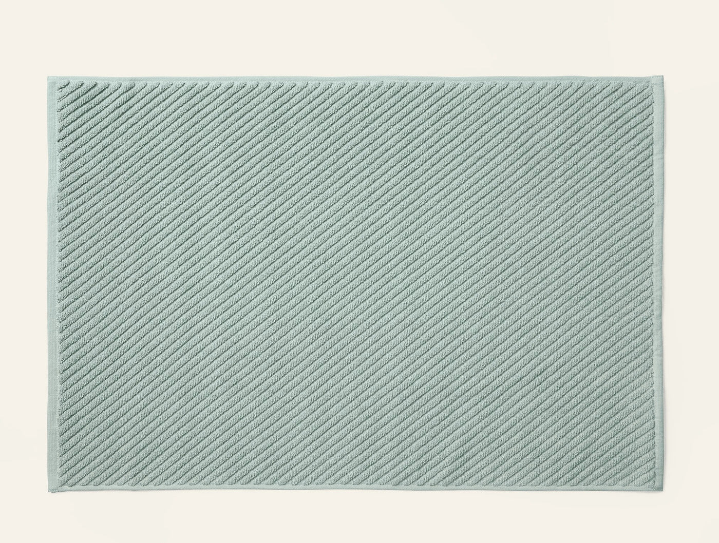 Coyuchi Air Weight bath rug in sage, diagonal ribbed twill texture, flat lay view.