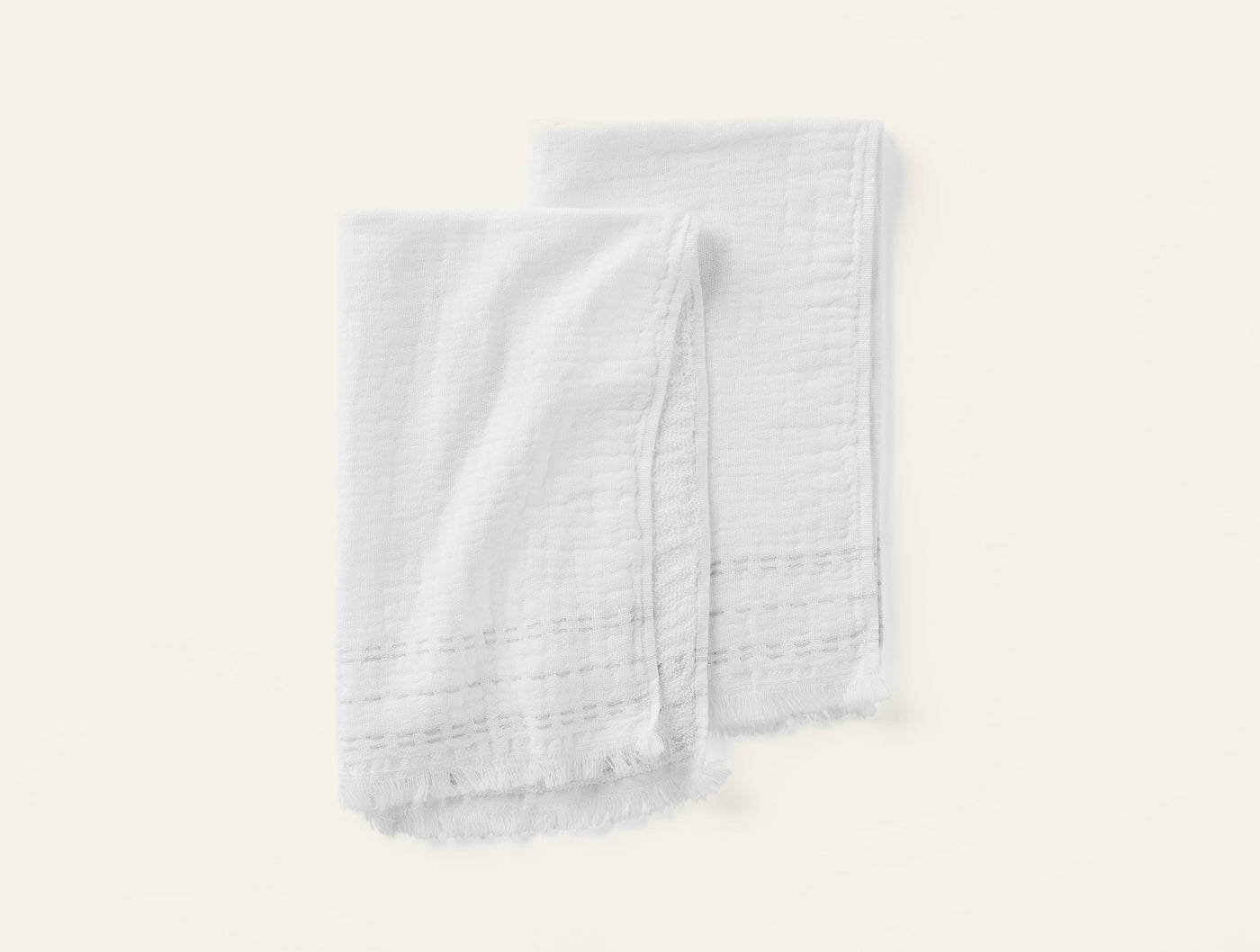 Coyuchi Alder hand towel pair in white with fringe hem and woven stripe detail.