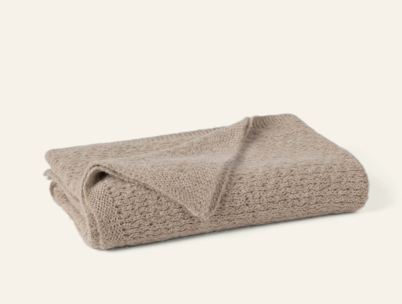 Coyuchi Alpamayo Suri Alpaca Knit throw in taupe, folded to show open-weave texture.