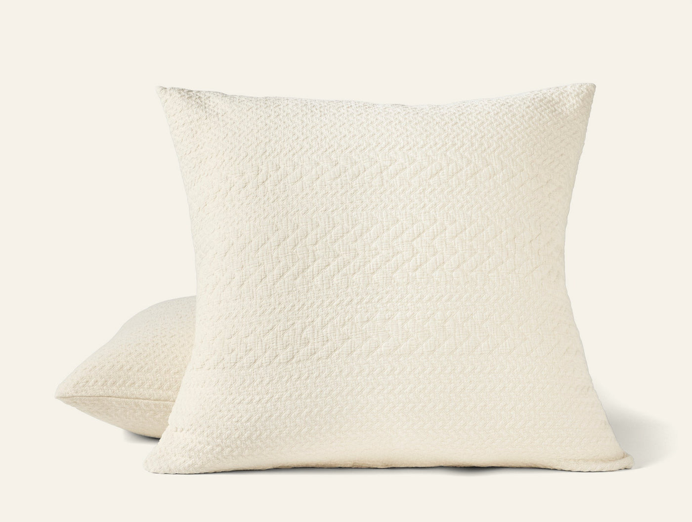 Pair of ivory Coyuchi Angeles Matelassé shams showing quilted diamond-weave texture.