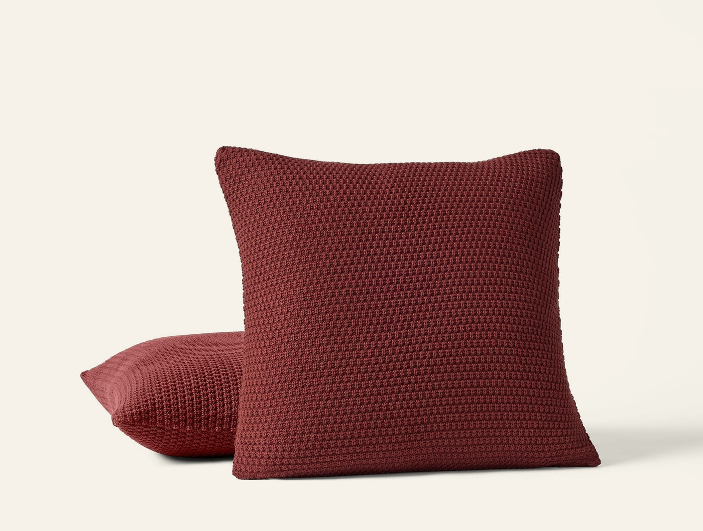 Coyuchi Avalon Knit pillow covers in garnet, showing textured popcorn knit detail.