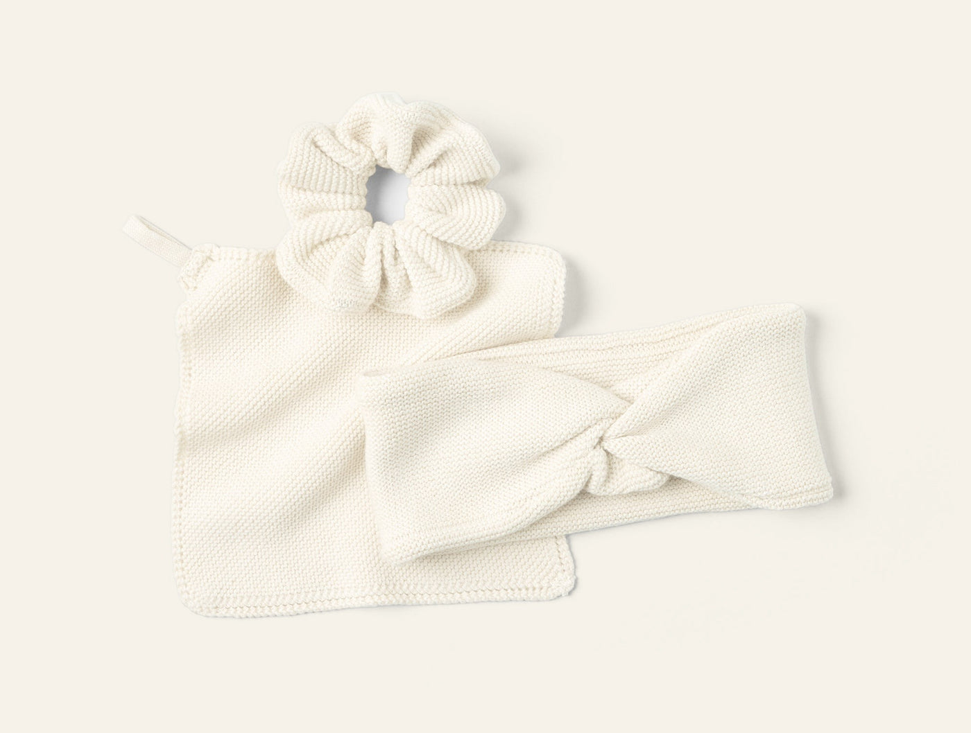 Coyuchi Bare knit gift set in ivory: scrunchie, headband, and washcloth laid flat.