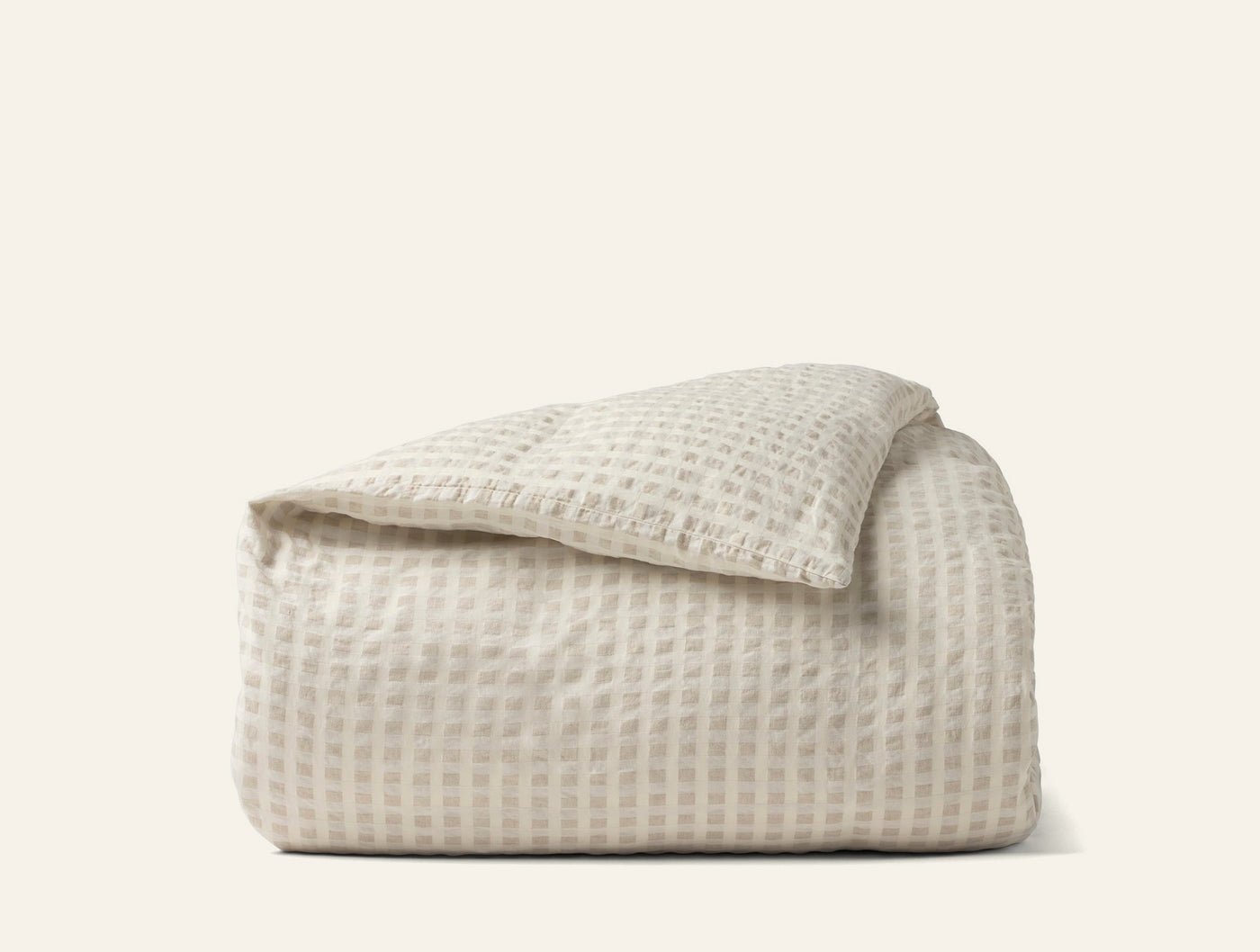 Coyuchi Birch duvet cover in ivory with textured waffle weave, folded neatly.
