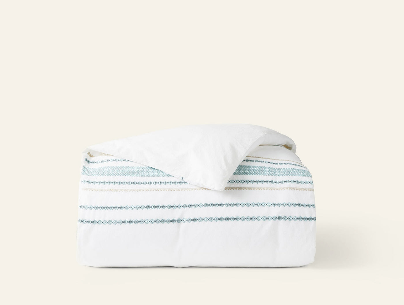 Coyuchi Cabrillo duvet cover in white with teal and sage embroidered stripe detail.