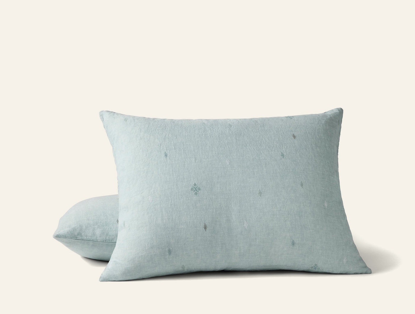 Close-up of two Cambria shams in misty blue linen with subtle embroidered dot motifs.