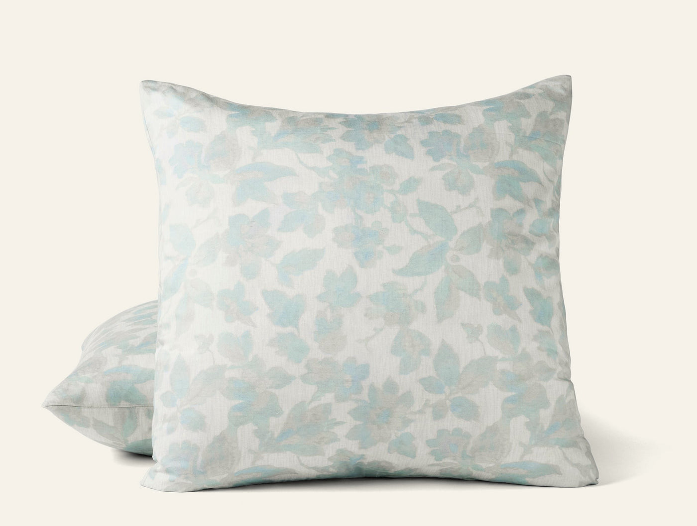 Close-up of Coyuchi Camellia Print sham in soft aqua floral pattern on ivory ground.