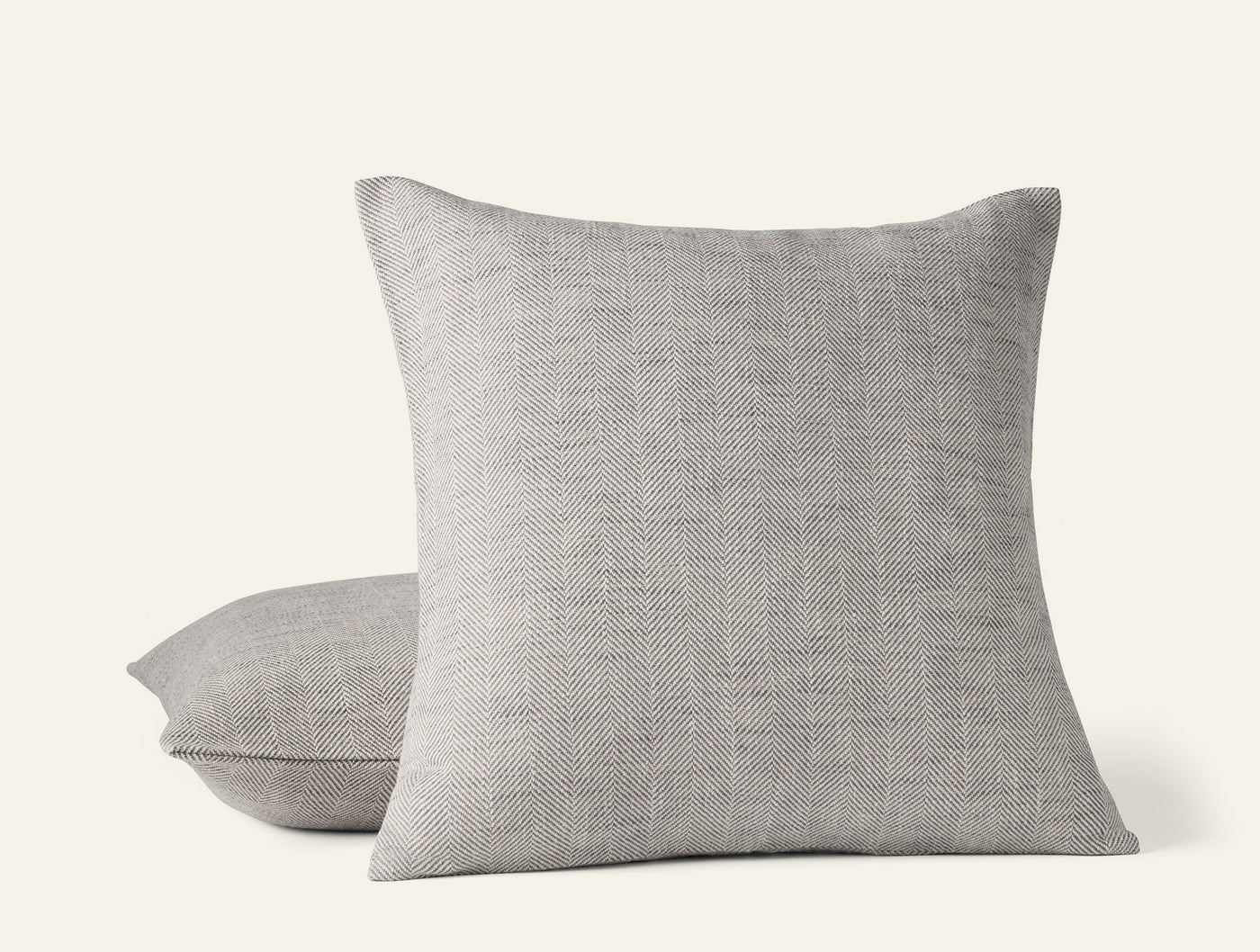 Coyuchi Canyon decorative pillow in warm grey woven linen, two pillows stacked.