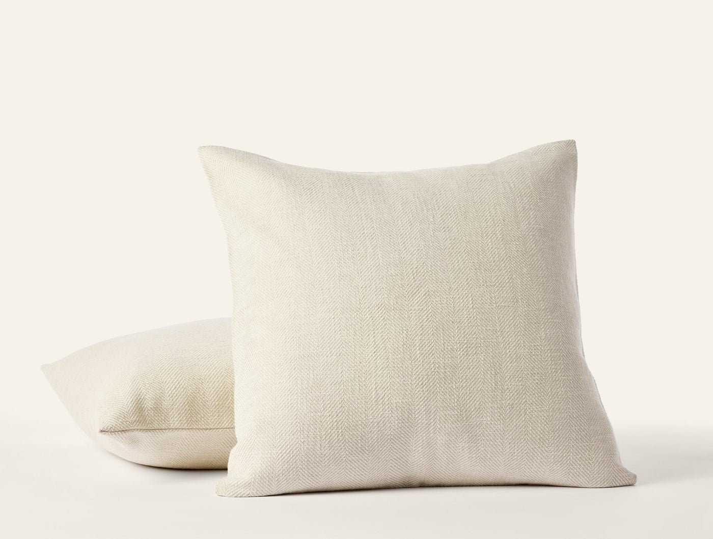 Two Coyuchi Canyon pillow covers stacked, natural linen weave texture visible in undyed ivory.