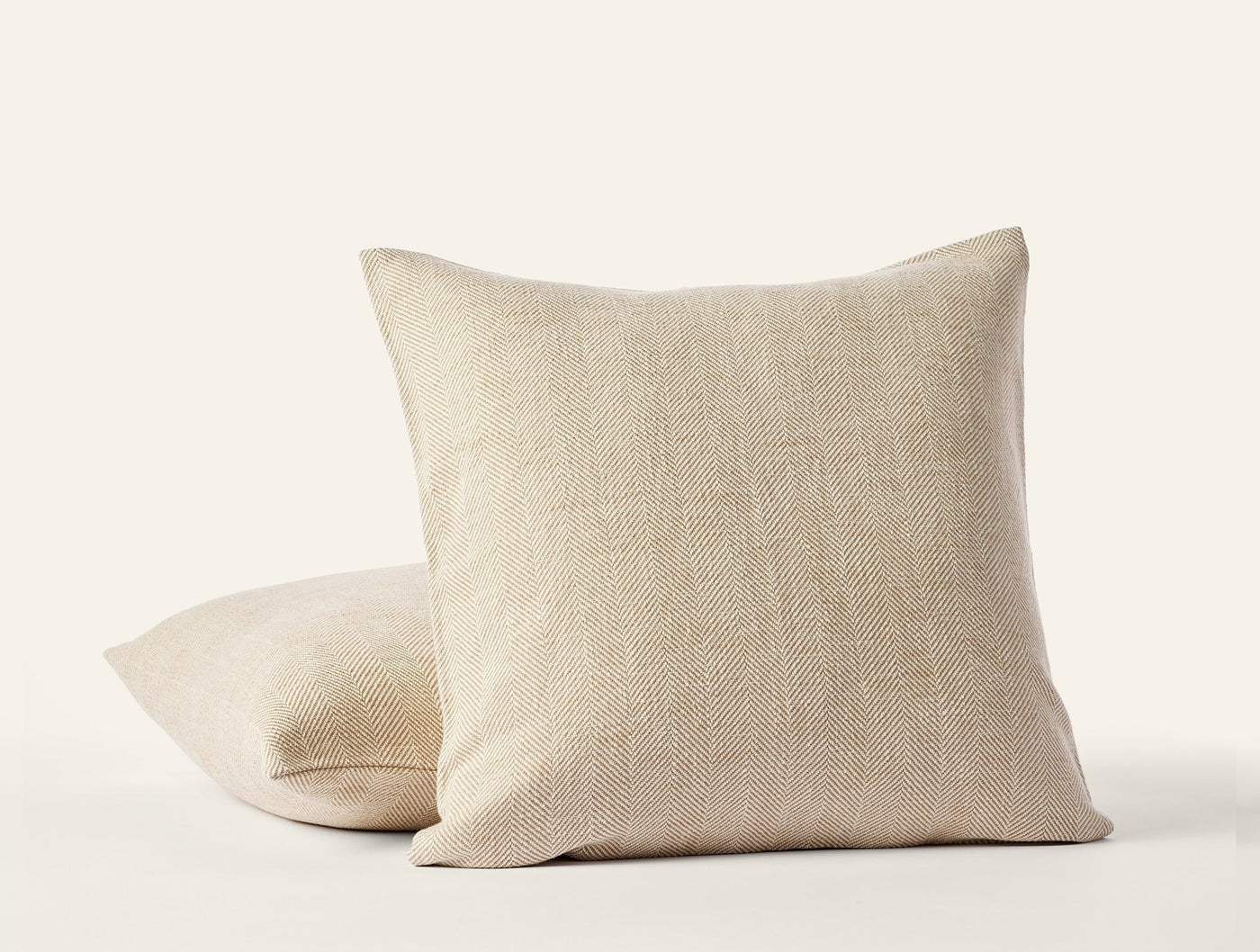 Two Coyuchi Canyon linen pillow covers stacked, natural oat tone, visible open weave texture.