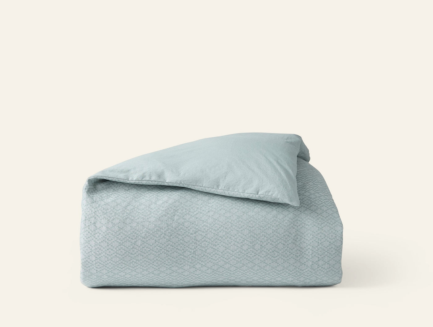 Coyuchi Capitola duvet cover in seafoam with subtle woven diamond pattern, neatly folded.