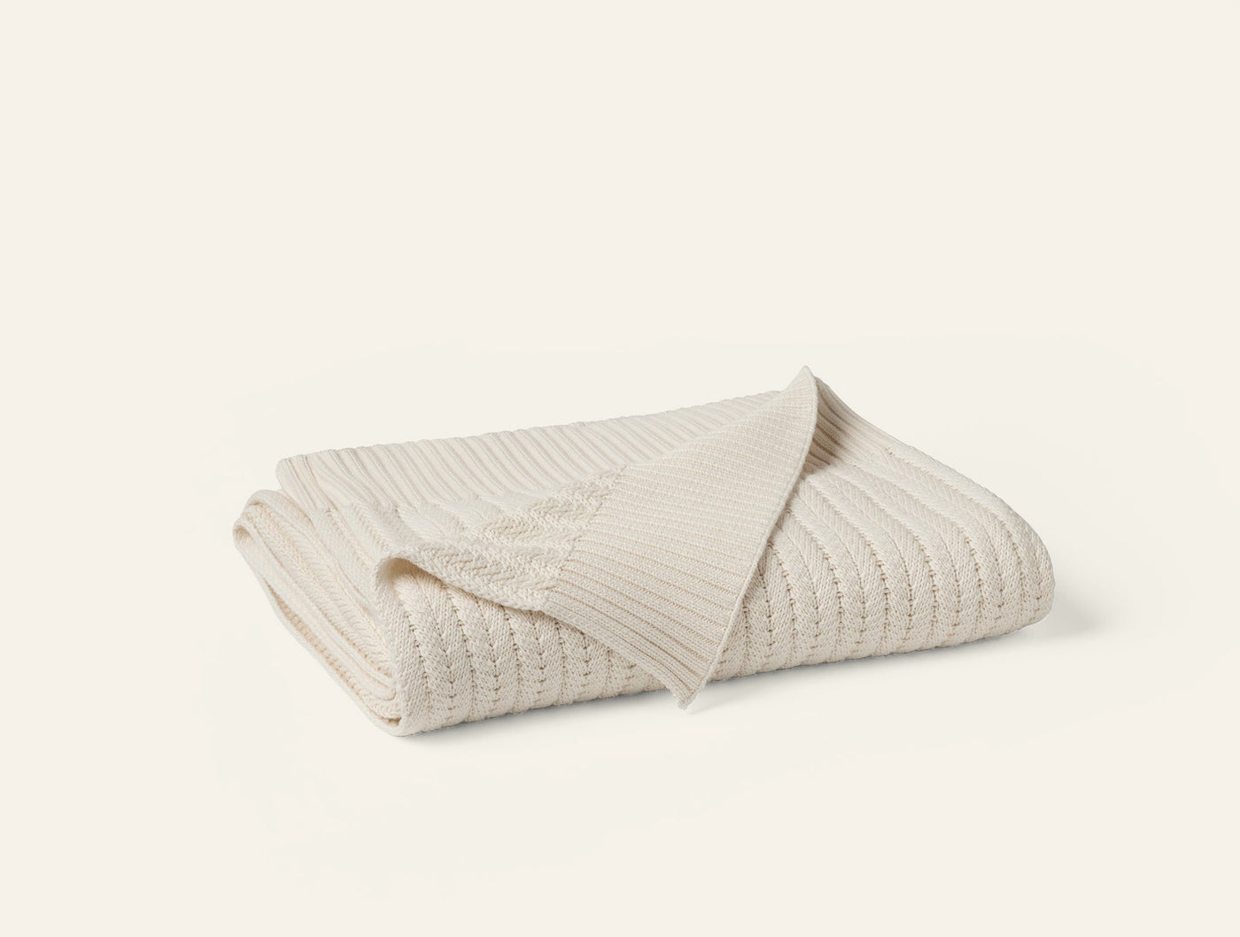 Close-up of ivory knit texture and folded edge detail on Coyuchi Casa Loma throw.