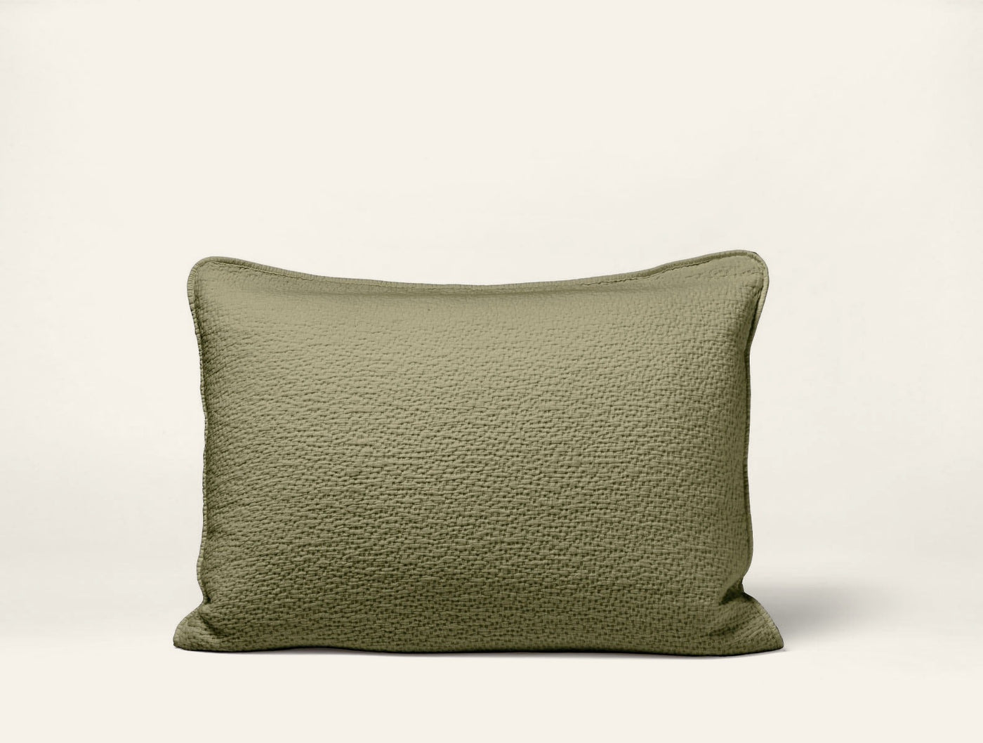 Olive green matelasse pillow sham with subtle textured surface and self-piped edge.