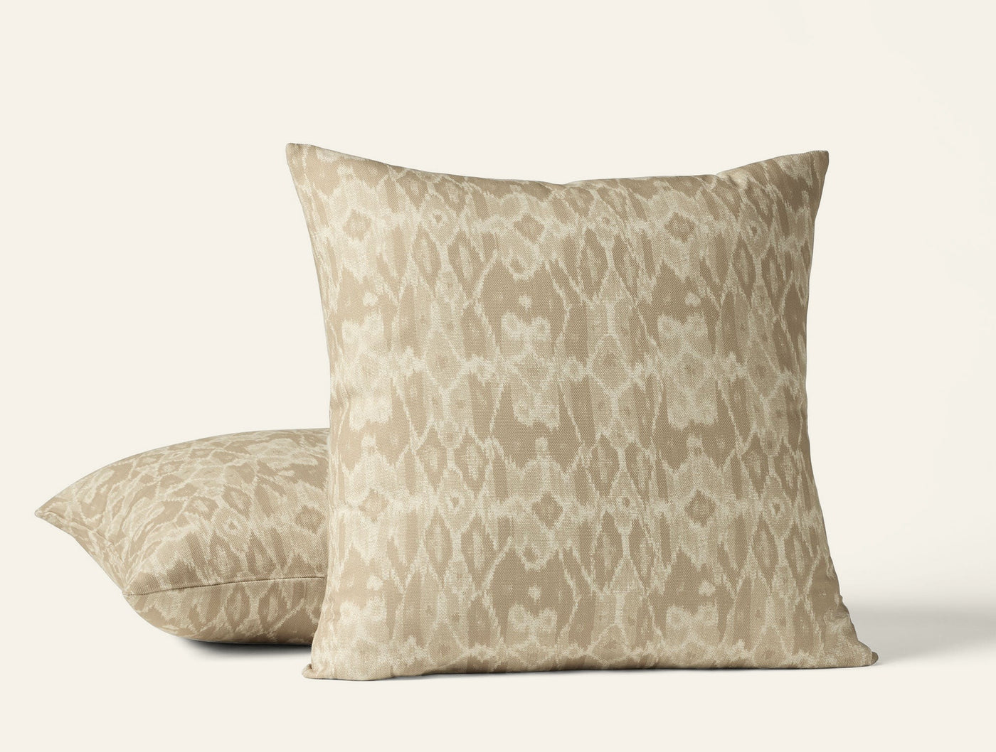 Two Coyuchi Cavallo Print pillows styled together, sand ikat pattern on linen.