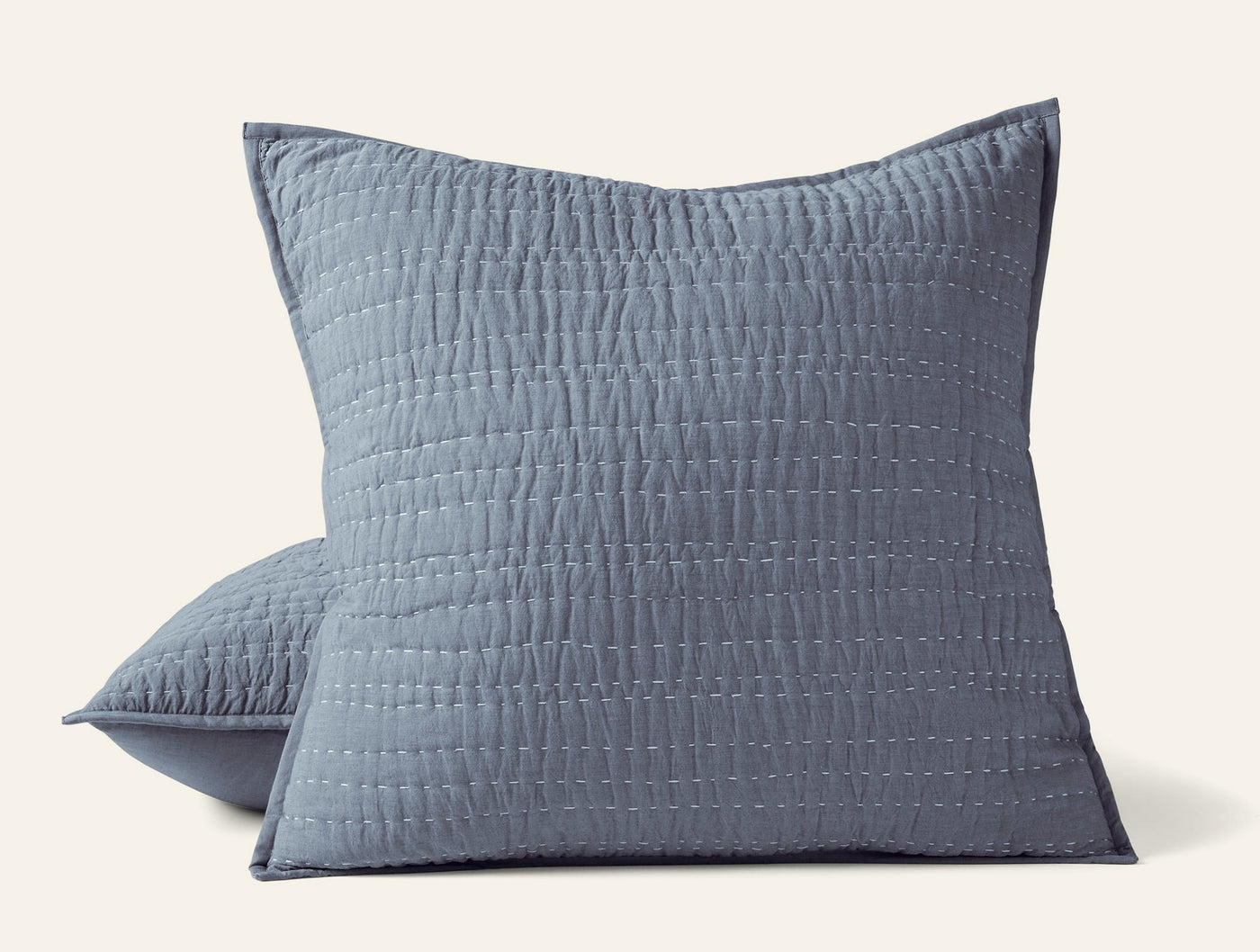 Two slate blue Coyuchi Channel Handstitched shams showing vertical quilted texture detail.