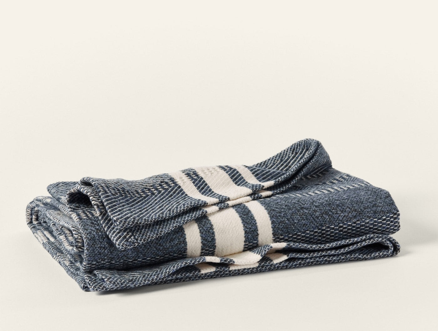 Navy herringbone throw with ivory stripes, folded to show texture and stripe detail.