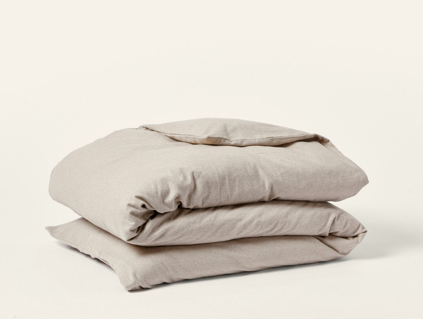 Coyuchi Cloud Brushed Flannel duvet cover folded in natural linen, showing soft texture.