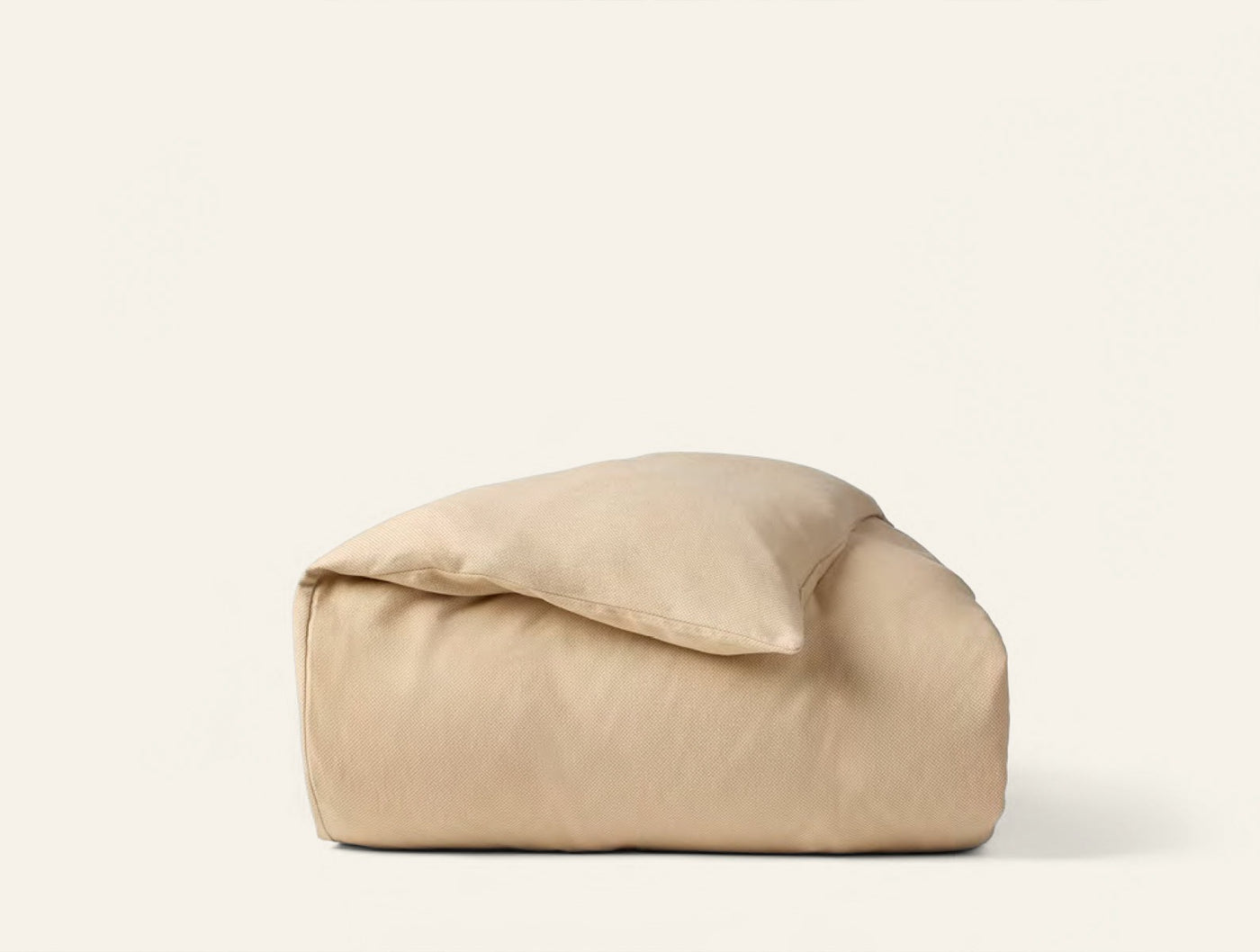 Coyuchi Cloud Brushed Flannel duvet cover folded in warm sand with pillow tucked inside.