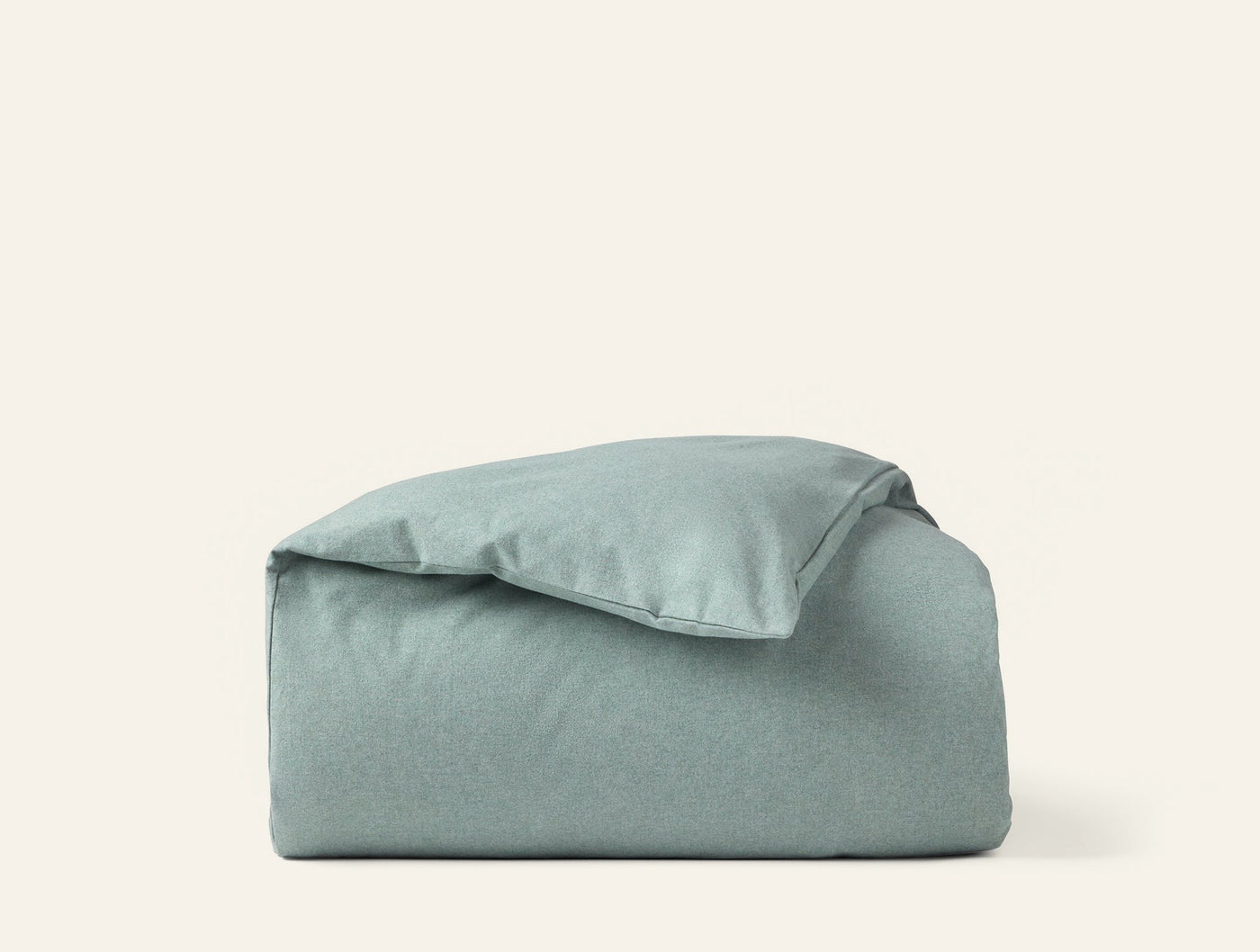 Sage green brushed flannel duvet cover folded and stacked against white background.