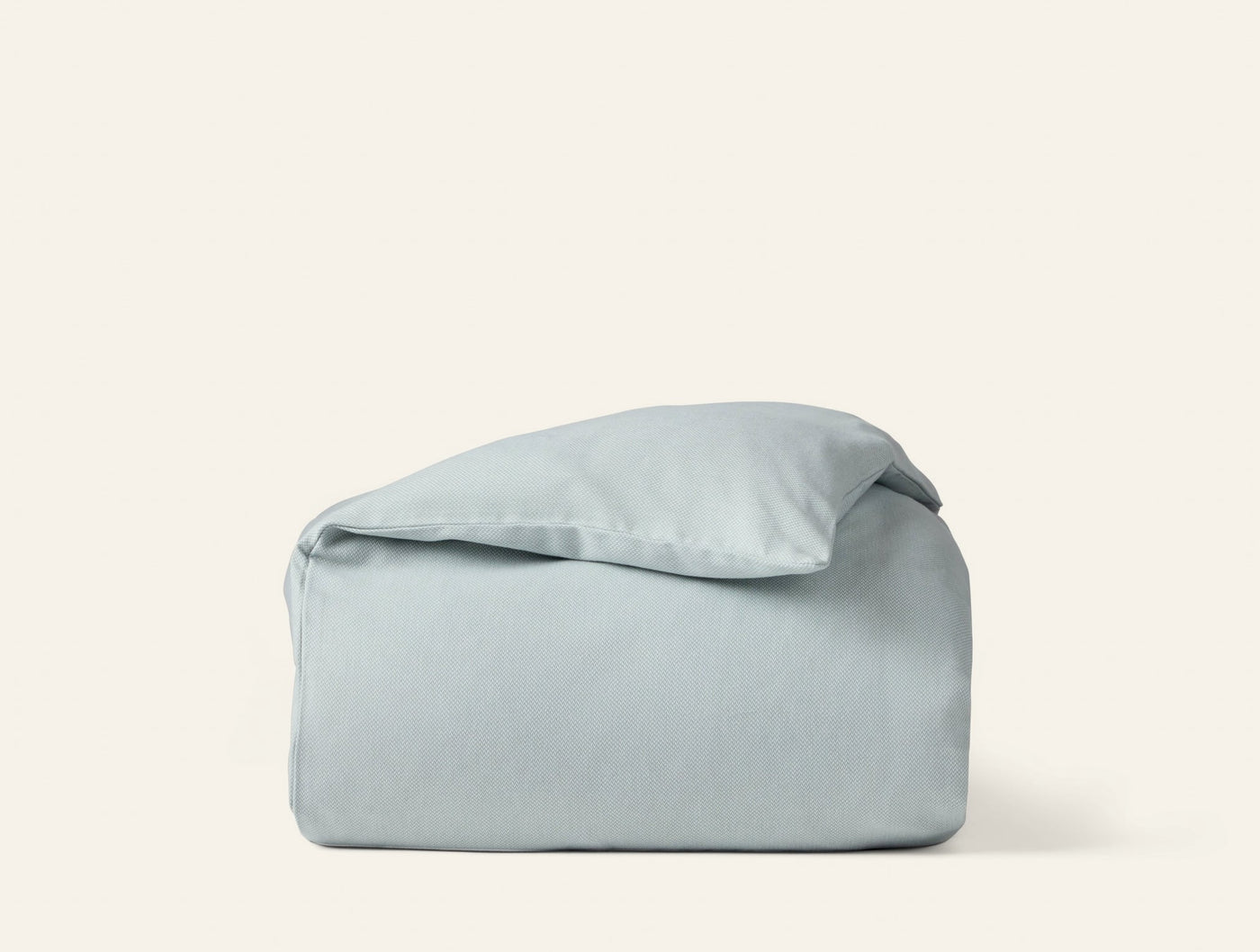 Coyuchi Cloud Brushed Flannel duvet cover folded neatly, pale sage blue-grey tone.