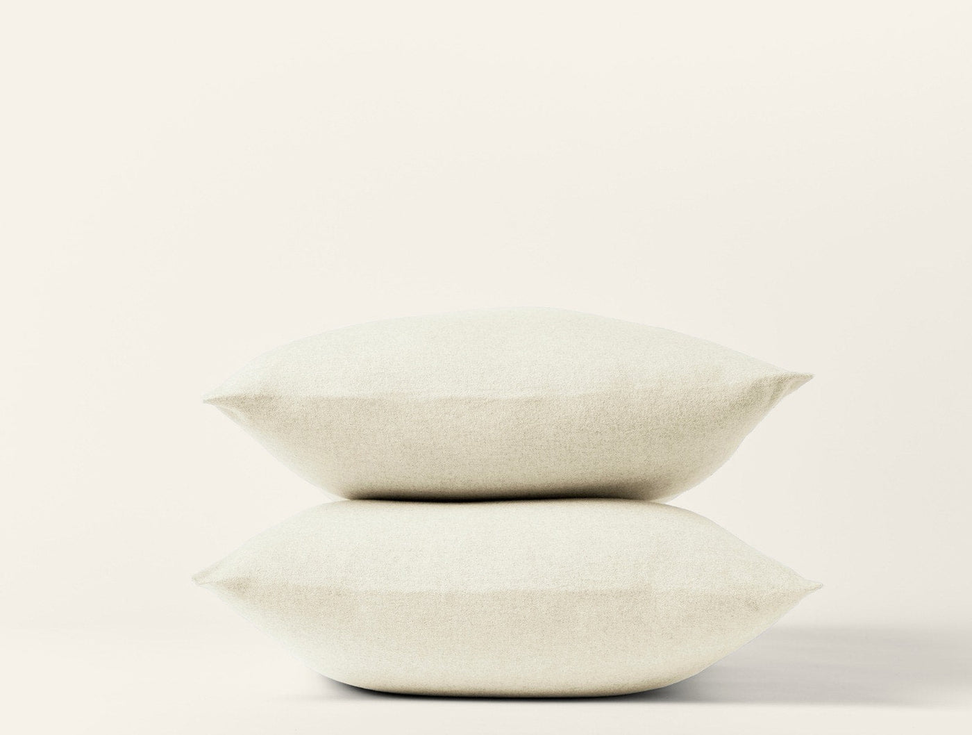 Two stacked ivory Coyuchi Cloud Brushed Flannel pillowcases against a white background.