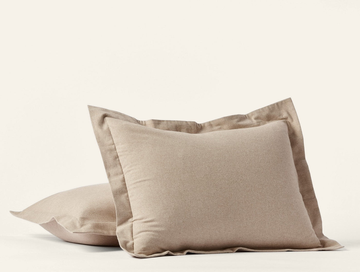 Close-up of two stacked Coyuchi Cloud Brushed Flannel shams in warm taupe with flange trim.