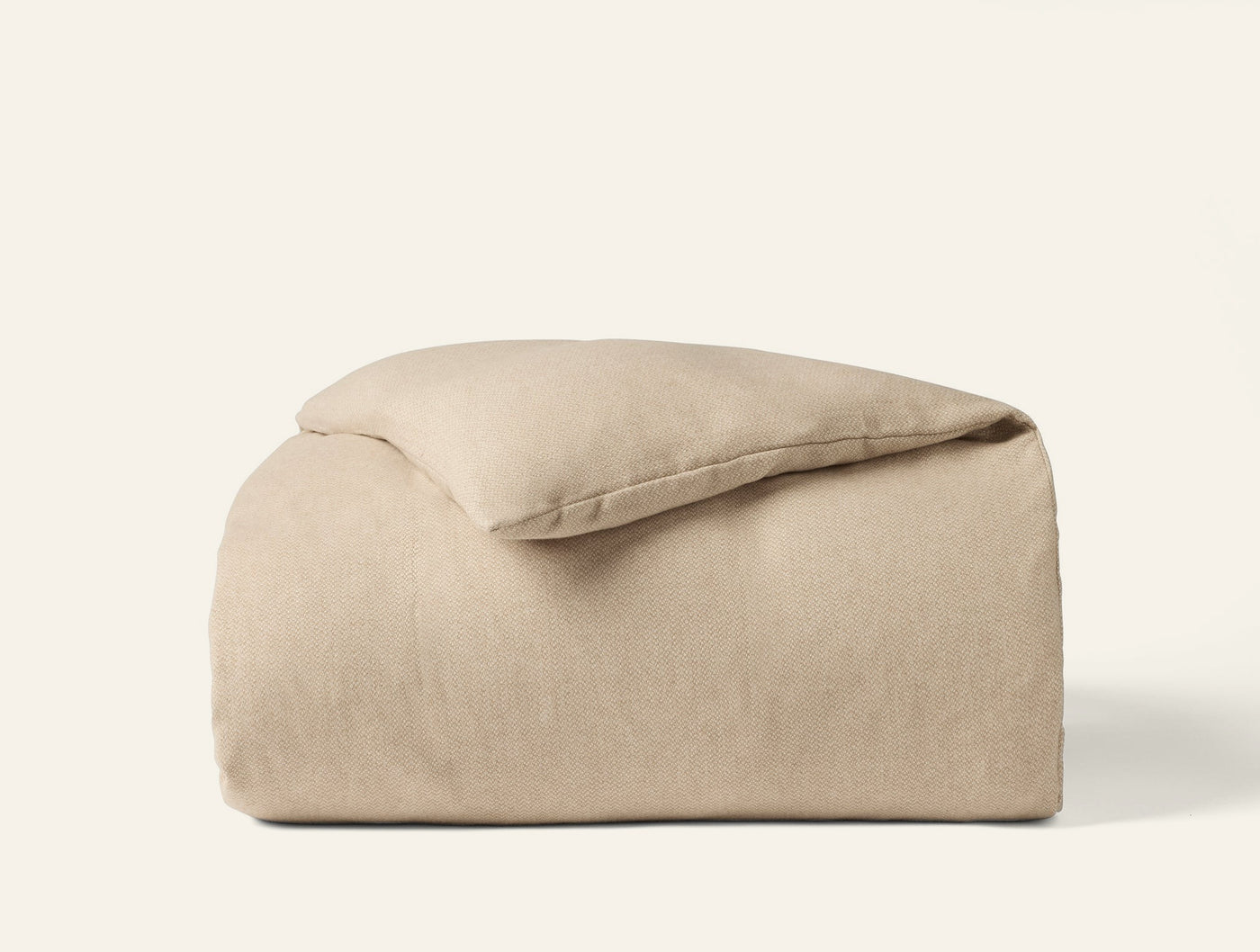 Close-up of folded oatmeal flannel duvet cover with softly brushed matte texture.