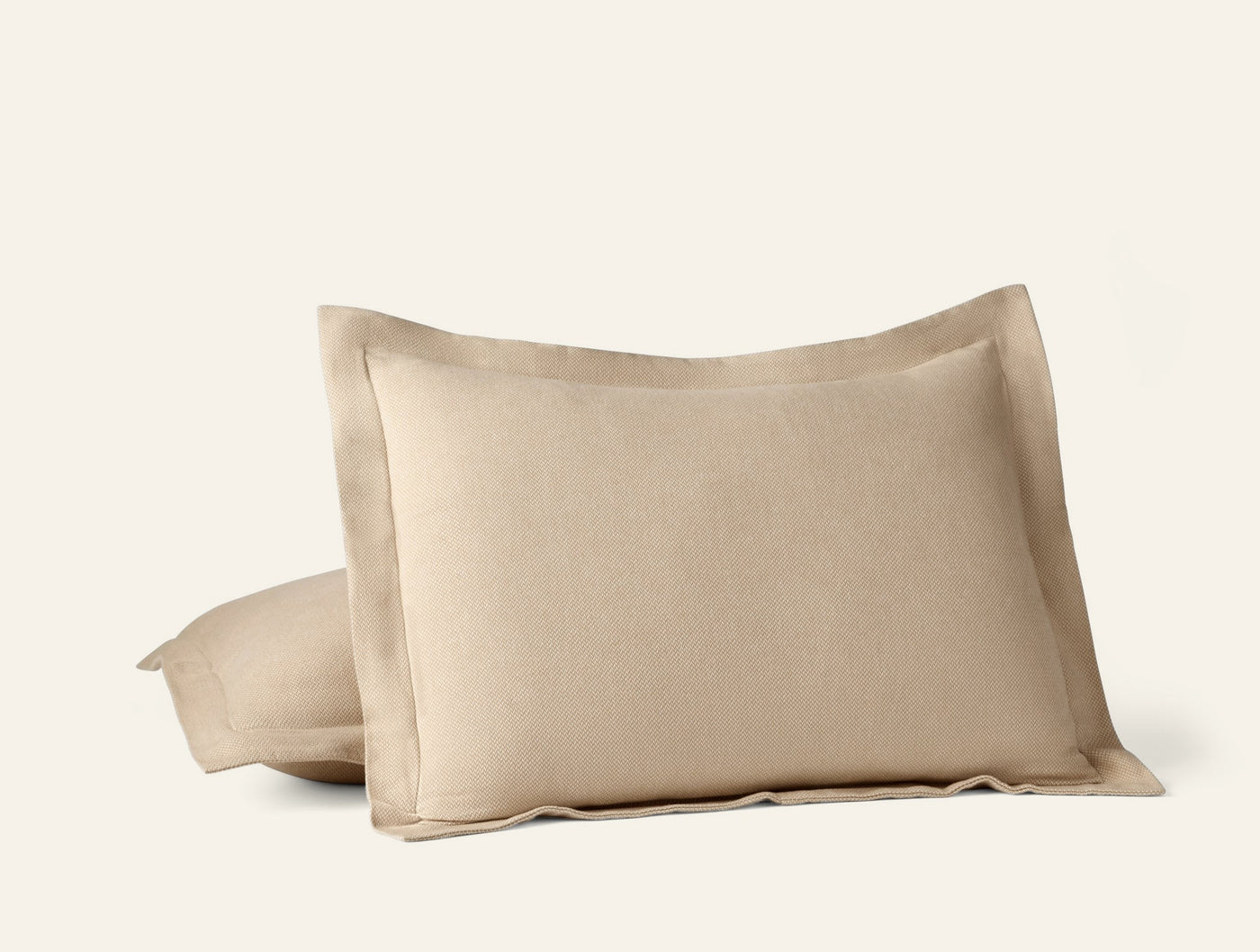 Close-up of Coyuchi Cloud Brushed Flannel pillow shams in warm sand with flanged edges.