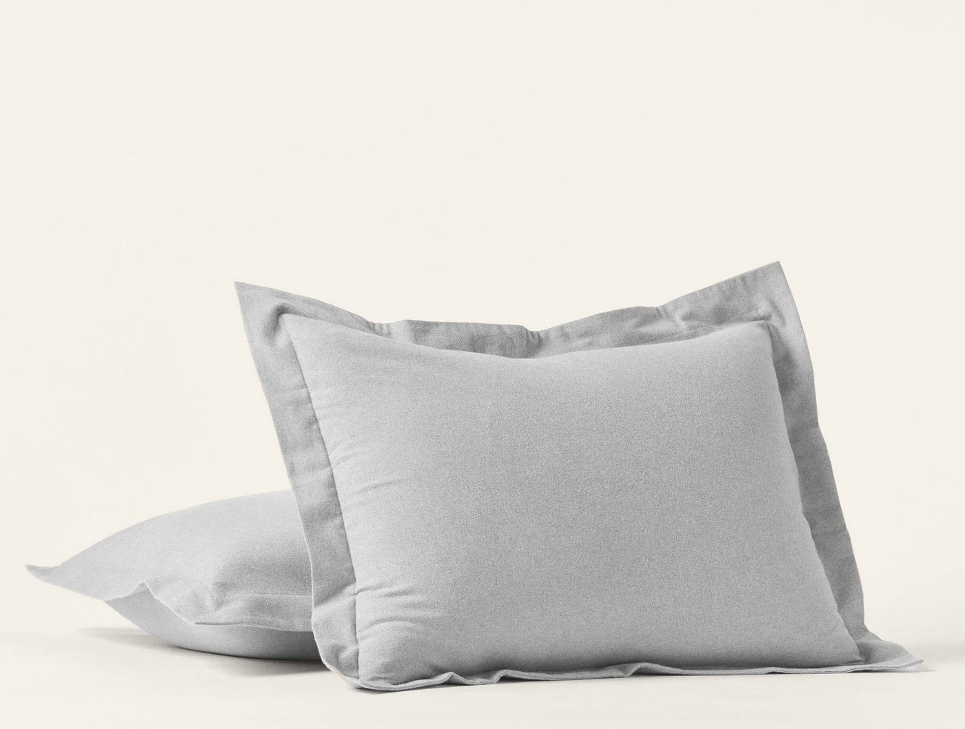 Close-up of two silver Coyuchi Cloud Brushed Flannel pillow shams with flange trim.