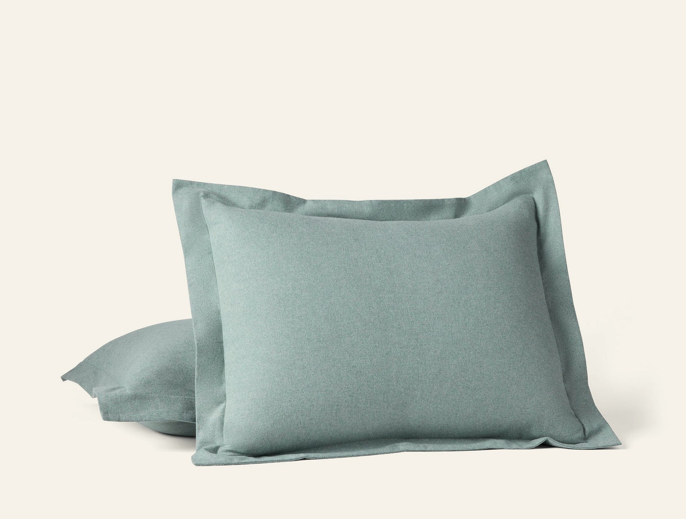 Close-up of two sage Cloud Brushed Flannel shams stacked, showing flanged edge detail.