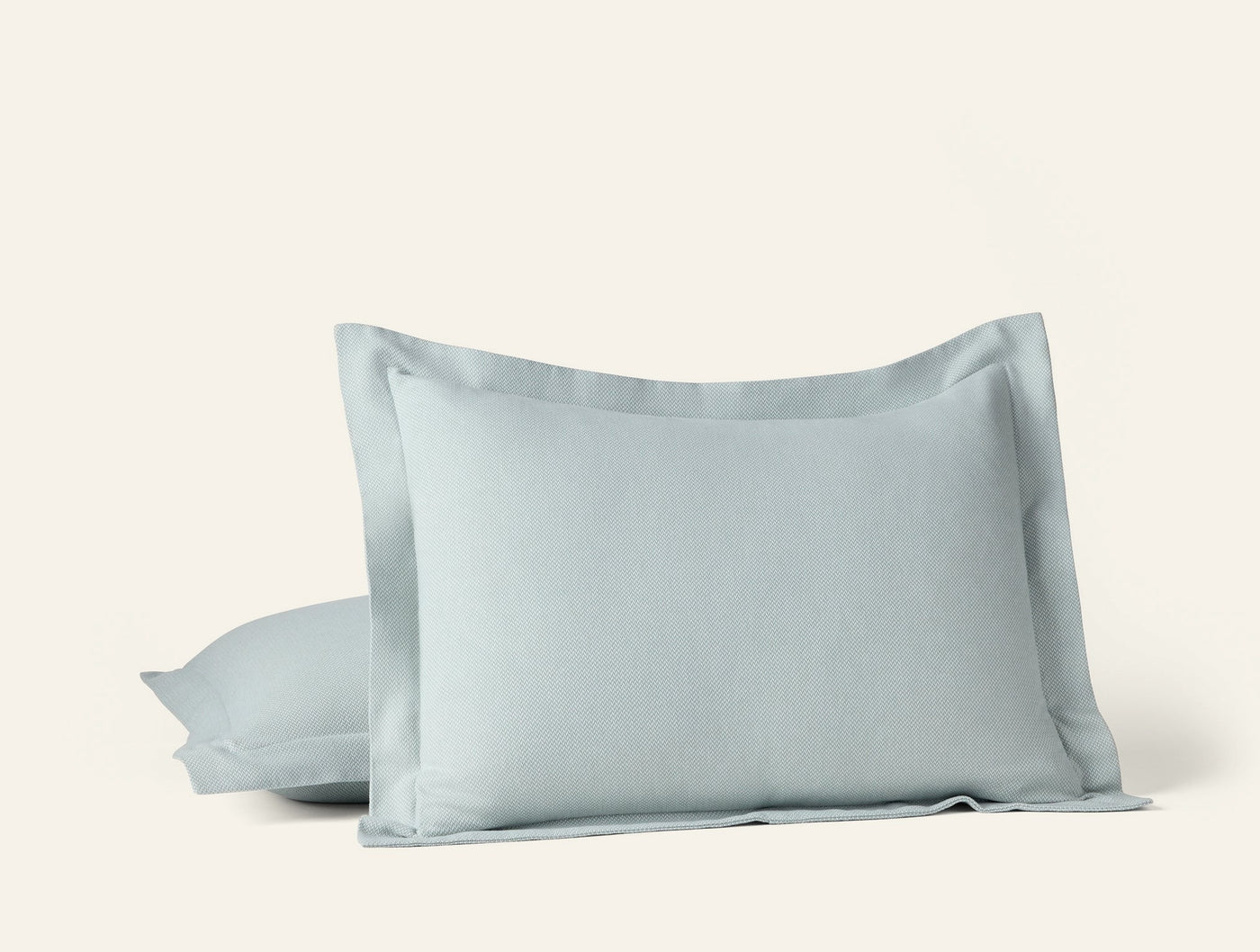 Close-up of two Coyuchi Cloud Brushed Flannel shams stacked in soft sage blue.
