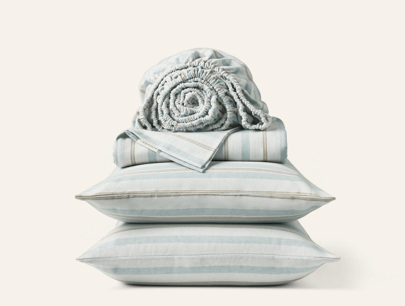 Close-up of stacked Coyuchi Cloud Brushed Flannel sheet set in pale aqua stripe with rolled fitted sheet on top.