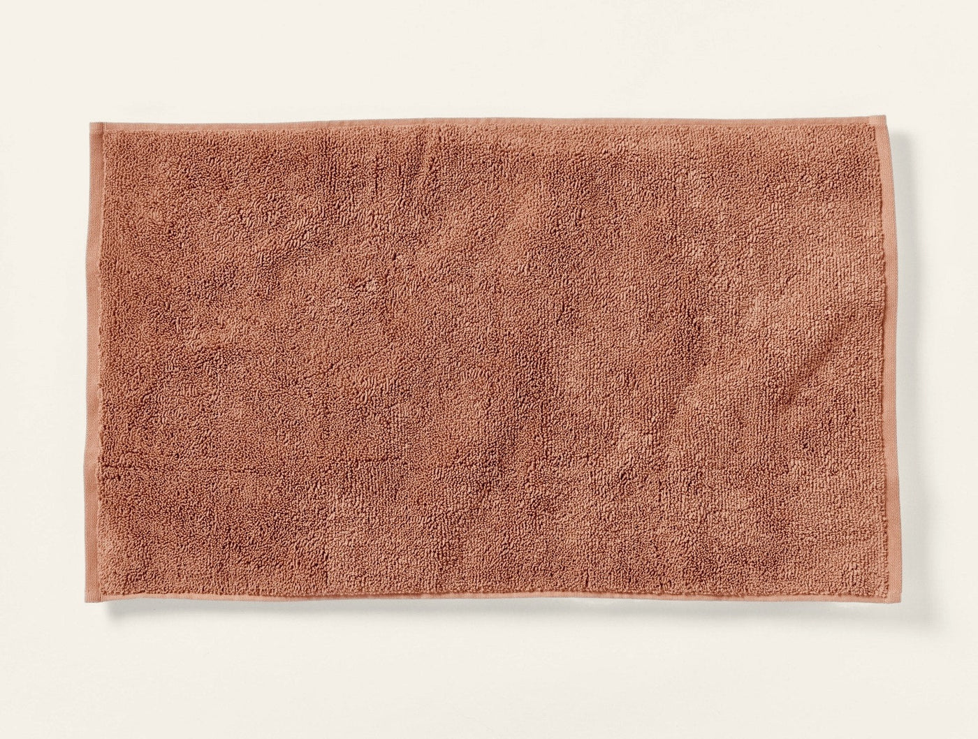 Flat-lay view of the Coyuchi Cloud Loom bath rug in terracotta with plush loop pile texture.