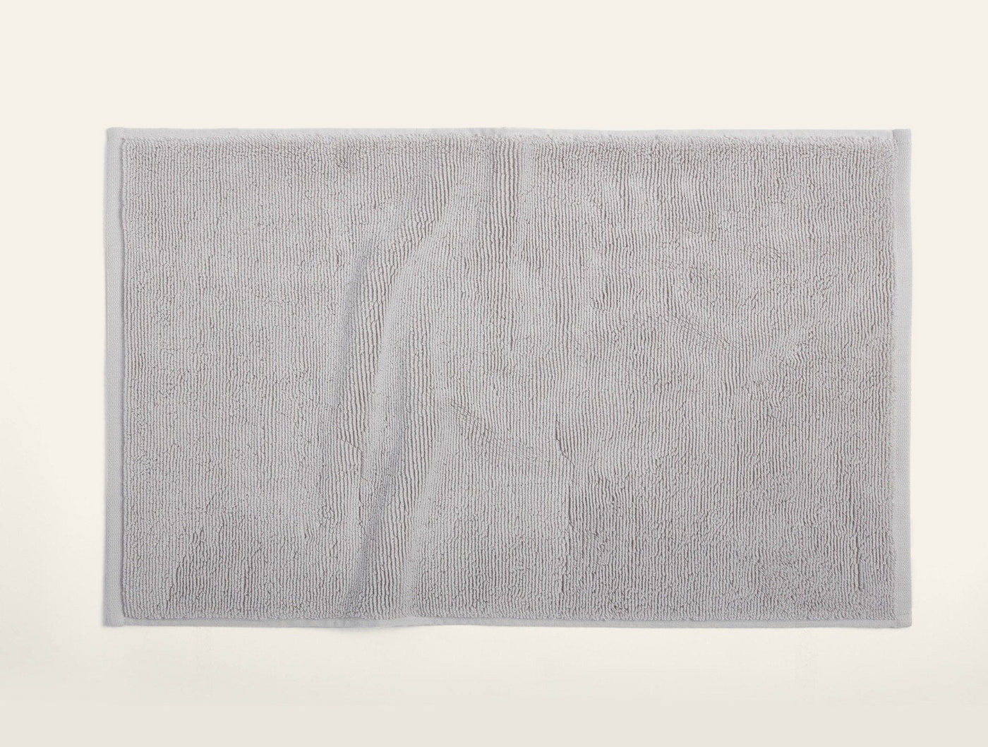 Coyuchi Cloud Loom bath rug in silver grey, flat lay showing full terry texture.